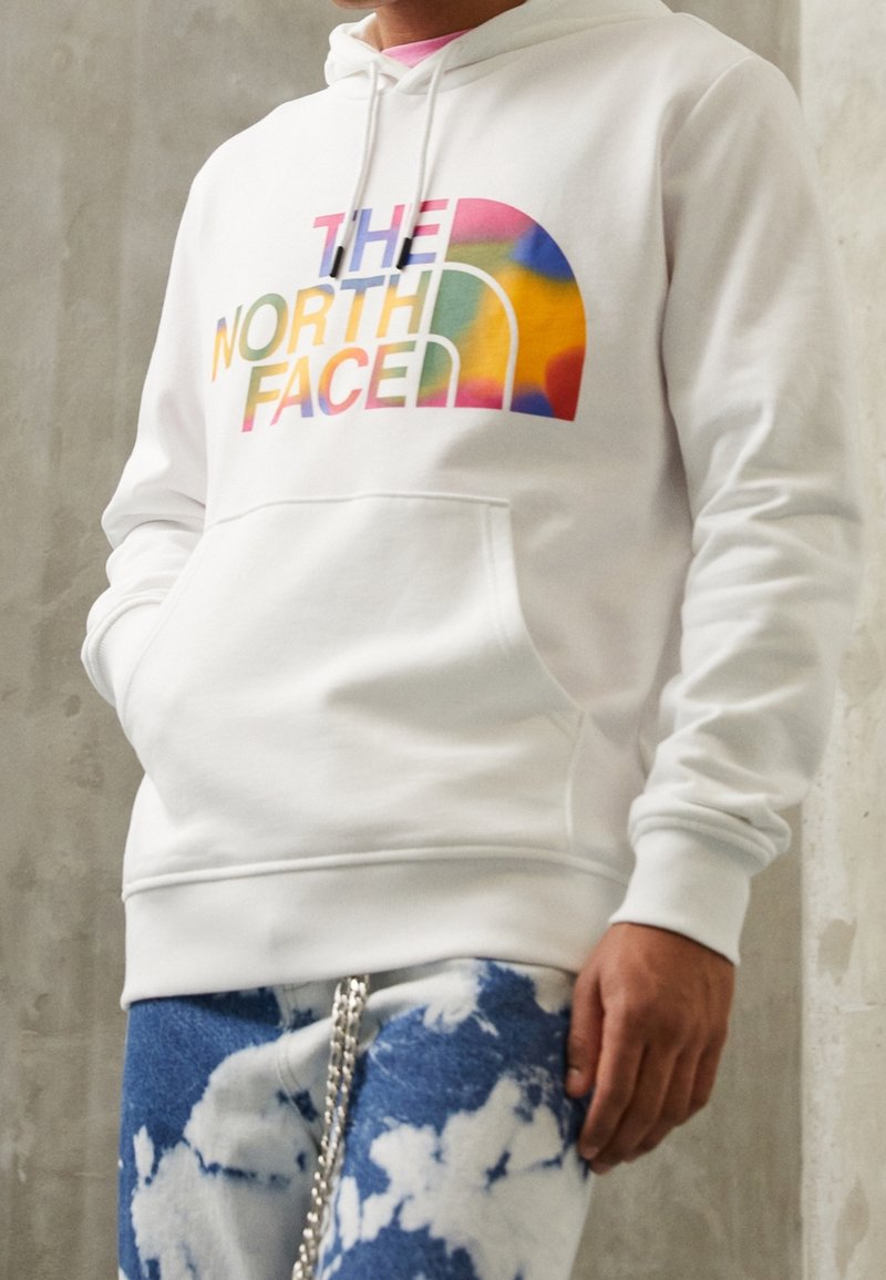 Felpa con cappuccio bianca in morbido cotone, con logo grafico multicolore di "The North Face" sul davanti. Tasca a marsupio frontale e cappuccio regolabile.