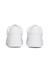 Paire de baskets basses blanches vues de dos avec un design sobre et « Tommy Jeans » embossé sur les semelles intermédiaires du talon.