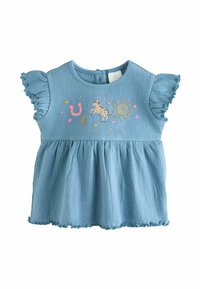 Haut en coton bleu avec des manches courtes à volants, en tissu texturé, et une taille froncée. Présente des détails brodés colorés : un cheval, un soleil et une lune.