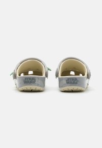 Gray and light cream clogs with rear strap, featuring “STAR WARS” logo and green accents, made of lightweight, durable material.