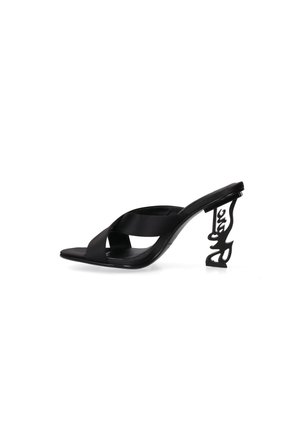 Sandale mule noire à talon haut avec des brides croisées et un talon sculpté présentant un motif ajouré abstrait.
