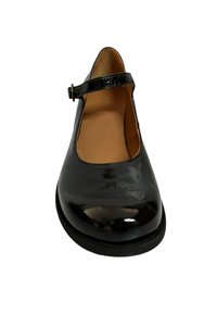 Zapato Mary Jane de cuero negro con acabado brillante, punta redonda y una correa ajustable delgada con hebilla plateada. Forro interior suave.