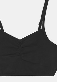 Bralette preto com alças ajustáveis, decote em V e detalhes franzidos no centro. Tecido suave com acabamento sem costuras.