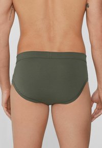Zielone bawełniane majtki o gładkiej teksturze, o średnim stanie, z konturowanym szwem z tyłu. Posiadają haftowaną talię dla dodatkowego komfortu.