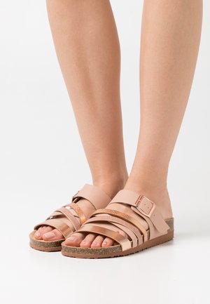 Lichtroze sandalen met meerdere banden, een gesp-accent en een kurken zool. De banden hebben een Glad en gestructureerd oppervlak.