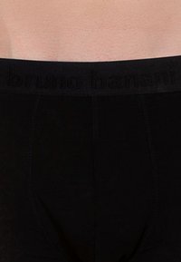 Svarta kalsonger för män med en texturerad elastisk midja som har den präglade logotypen "bruno banani". Slät tyg med en åtsittande design.