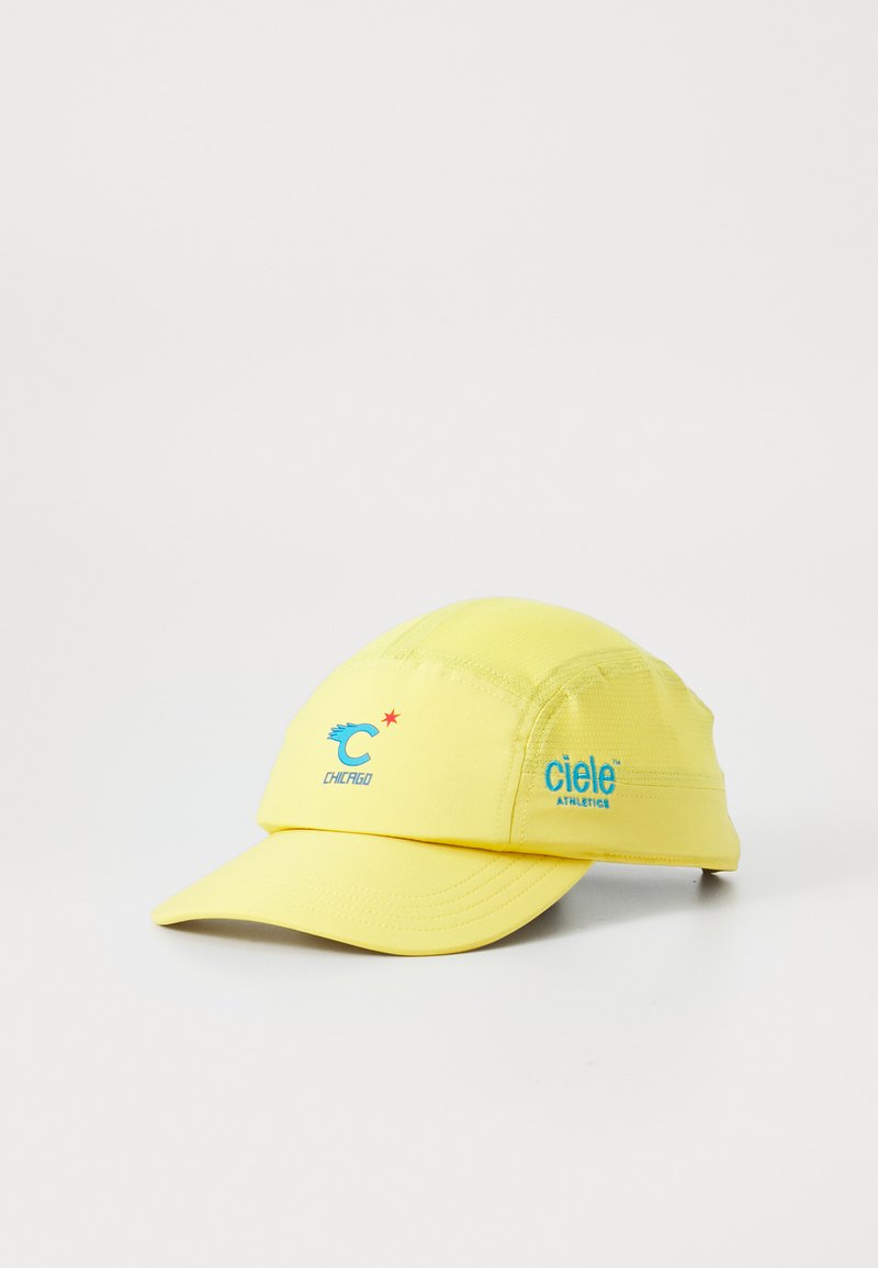 Yellow running cap with blue "ciele athletics" embroidered on side and blue "C Chicago" logo with red star on front panel.