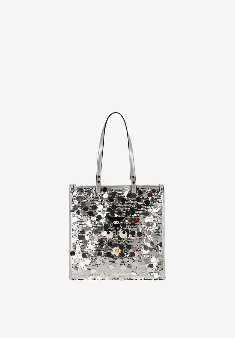 Bolso tote plateado cubierto de grandes lentejuelas con pines frontales en forma de ojo de dibujo animado, corazón y comida, que cuenta con doble asa de hombro.
