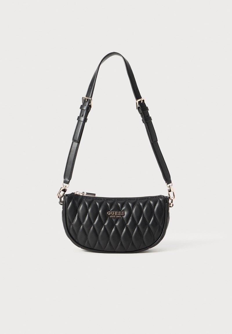 Sac à bandoulière en cuir matelassé noir avec sangle réglable et logo doré "GUESS EST 1981" sur le devant.