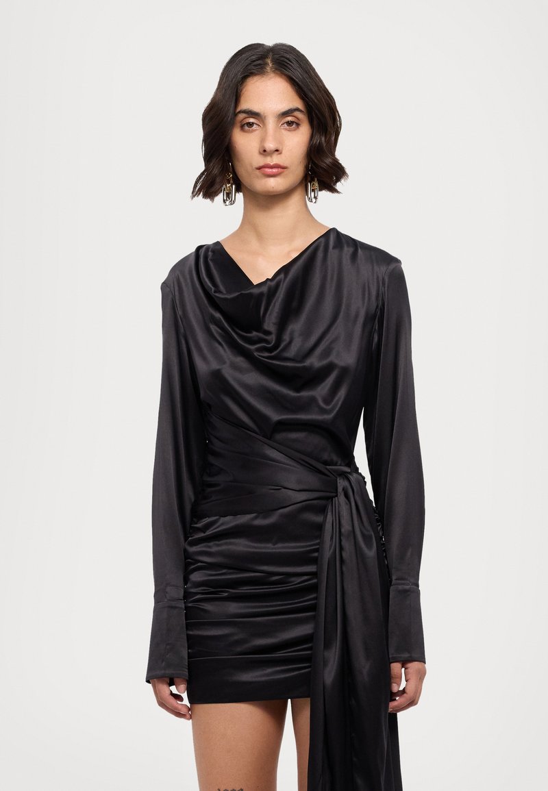 Vestido de satén negro con mangas largas, escote drapeado y silueta ajustada. Presenta detalles fruncidos en el cuerpo y un cinturón atado en la cintura.