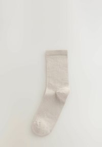 Bež čarapa od pamuka s rebrastom teksturom, dužine do sredine lista, ojačanim prstom i glatkim rubom. Minimalistički dizajn, pogodan za različite prilike.