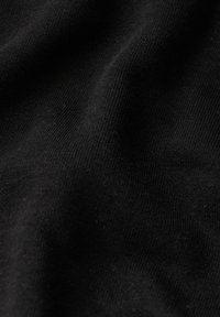 Tejido de estiramiento negro con una textura suave y lisa, que presenta líneas sutiles y pliegues suaves, indicando flexibilidad y caída.