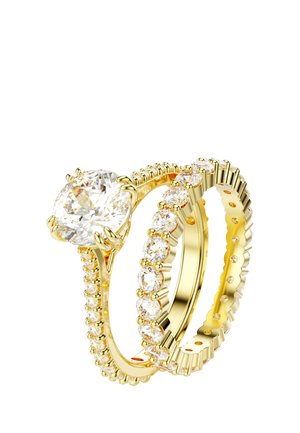 Dwa złote pierścionki z diamentami o okrągłym szlifie; jeden pierścionek ma duży diament soliter, drugi to obrączka wieczności z diamentami dookoła.