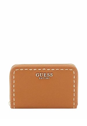 Portefeuille zippé en cuir tanné avec bordure blanche surpiquée et logo argenté "GUESS EST 1981" sur le devant.