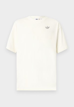 Bijela majica kratkih rukava s okruglim izrezom i malim sivim Adidas trefoil logotipom na lijevoj strani prsa.