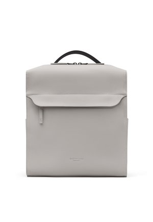Minimalistische lichtgrijze vierkante rugzak met voorvak met rits, zwart handvat en subtiele logo-opdruk onderaan in het midden.