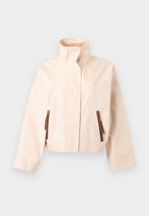 Μπεζ κοντό σακάκι με ψηλό όρθιο γιακά, μακριά μανίκια, κουμπιά με κλιπ στο μπροστινό μέρος και δύο κάθετες καφέ τσέπες με φερμουάρ.