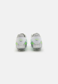 Scarpe da calcio bianche con accenti verde neon, dotate di tomaia sintetica, tacchetto testurizzato e tacchetti in gomma per la trazione.