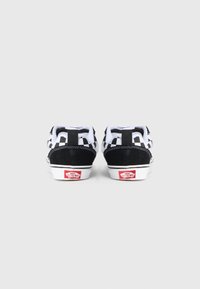 Svart-hvite rutete lave sneakers laget av semsket skinn og lerret, hvit mellomsåle og røde logo aksenter på hælen.