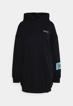 Sweat à capuche noir oversize avec texte "Replay Rose Label" à l'avant et un écusson bleu sarcelle avec une broderie florale rose sur la manche gauche.
