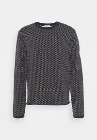 Marinblå långärmad tröja med ett geometriskt mönster i vitt och guld, rund halsringning och ribbade ärmslut och nederkant. Mjuk textur.