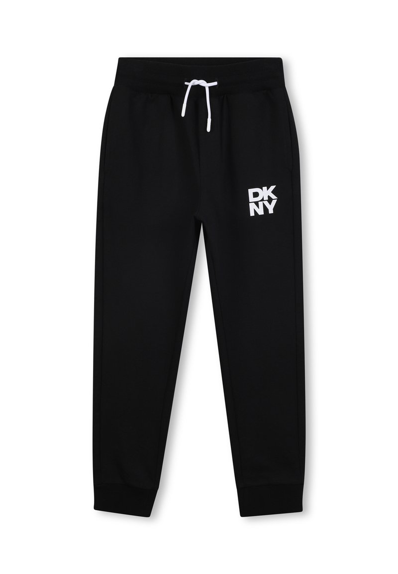 Pantalons de survêtement noirs en tissu doux, arborant un logo blanc DKNY sur la cuisse gauche, une taille élastique et des chevilles resserrées.