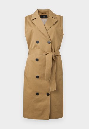 Ærmeløs, tan trenchcoat-kjole med brede revers, dobbeltradede sorte knapper, sidelommer og bælte til at binde i taljen.