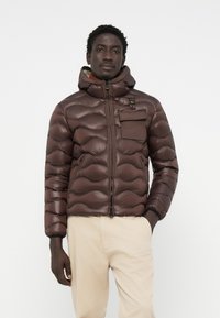 Braune Pufferjacke mit Kapuze, mit gewelltem Nähen, Reißverschluss vorne, Brusttasche und elastischen Bündchen. Glatte Textur, leichtes Design.