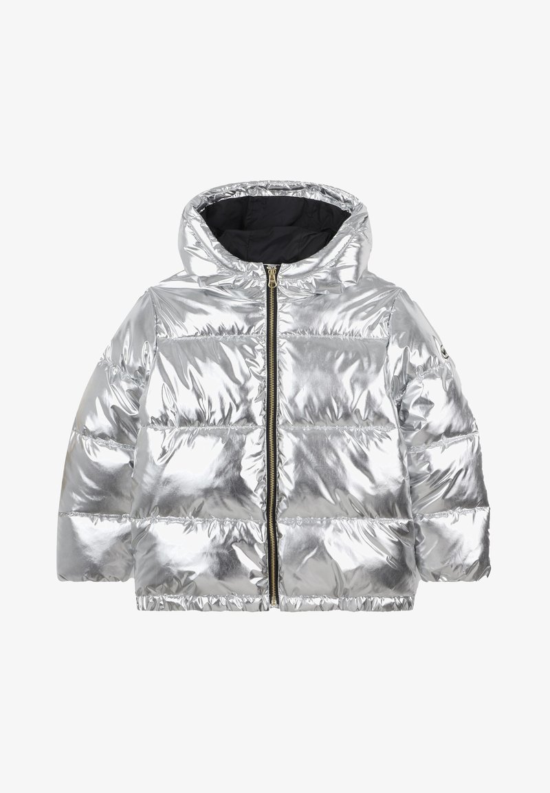 Doudoune argentée avec capuche, présentant une texture brillante, une fermeture éclair à l'avant et un design à panneaux cousus. Doublure intérieure noire.