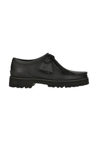 Chaussure noire en cuir à lacets avec semelle épaisse et pampilles décoratives, vue de côté sur fond blanc.