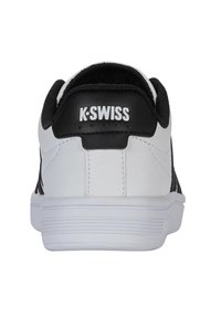 K-Swiss tenisky s hladkým bílým koženým svrškem, černými akcenty, polstrovaným límcem a texturovanou bílou gumovou podrážkou.