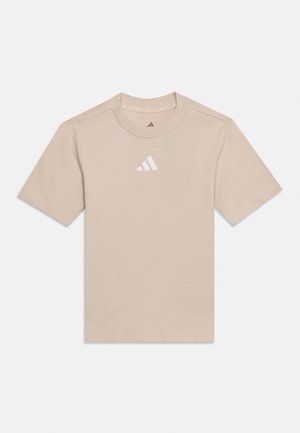 T-shirt beige a maniche corte Adidas con scollo rotondo e logo bianco Adidas centrato sul petto, distesa su sfondo bianco.