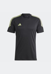 Svart kortärmad träningströja med ett gult tre-stripes mönster på axlarna. Lätt och andningsbart tyg med rundad halsringning.