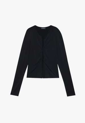 Melna ilga piedurkne tops, izgatavots no viegla, gluda auduma. Ievērojama V veida kakla izgriezums un frēzēts detaļas priekšpusē, radot pieguļošu formu.