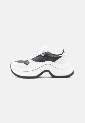 White and black sneaker with a textured pattern, rounded sole, and silver accents. Features a thick, curved platform and laces.