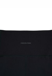 Czarne legginsy sportowe o matowym wykończeniu, z płaskim paskiem w talii i szwem z tyłu, z logo "CHELSEA PEERS" w kolorze szarym.