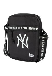 Borsa a tracolla nera in nylon con logo bianco dei New York Yankees, dotata di una tracolla decorata con la scritta "NEW YORK" e chiusura a zip.