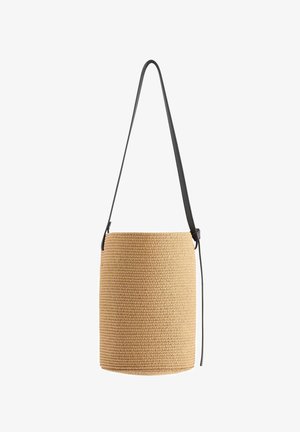 Cylindrisk vævet halmspand taske med lang justerbar sort læder skulderrem.