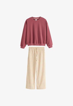 Pullover mit langen Ärmeln in staubigem Rosaton, kombiniert mit lockeren, hoch taillierten cremefarbenen Hosen mit einem weichen orangefarbenen Karomuster und elastischem Bund.