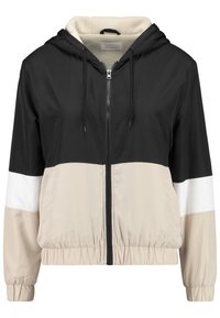 Kurtka z kapturem, utrzymana w kolorystyce blokowej w kolorach czarnym, beżowym i białym. Wykonana z lekkiego materiału, z zamkiem błyskawicznym z przodu i elastycznymi mankietami.