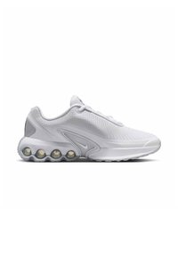 Zapatilla deportiva blanca con parte superior de malla, punta redondeada y suela acolchada con bolsas de aire visibles. Sutiles acentos grises en el talón.
