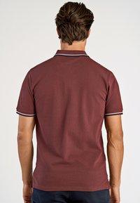 Bordeaux polo z niebieskim i białym paskiem na kołnierzyku oraz rękawach. Krótkie rękawy, klasyczny krój, materiał z mieszanki bawełny, o teksturowanym wykończeniu.