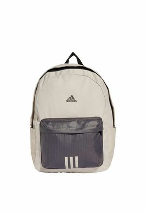 Zaino beige chiaro con una tasca frontale grigia, zip nera e design a tre strisce bianche. Dotato di spallacci imbottiti e maniglia superiore.