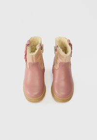 Ζευγάρι ροζ μπότες για μωρά με μπεζ φλις επένδυση, υφασμάτινη δερμάτινη μπροστινή πλευρά, γυαλιστερή σουέτ επάνω με διακόσμηση λουλουδιών και ανοιχτό καφέ καουτσούκ σόλες.