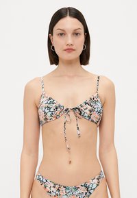 Bikini-setet har ett blommönster i pastellfärger, justerbara axelband, en knut fram och en matchande botten med låg midja.