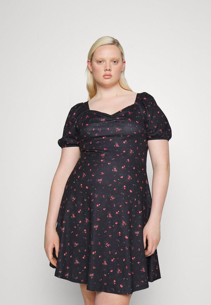 Vestido preto com mangas curtas bufantes, decote quadrado e corpete ajustado. O tecido tem um padrão floral em vermelho e rosa.