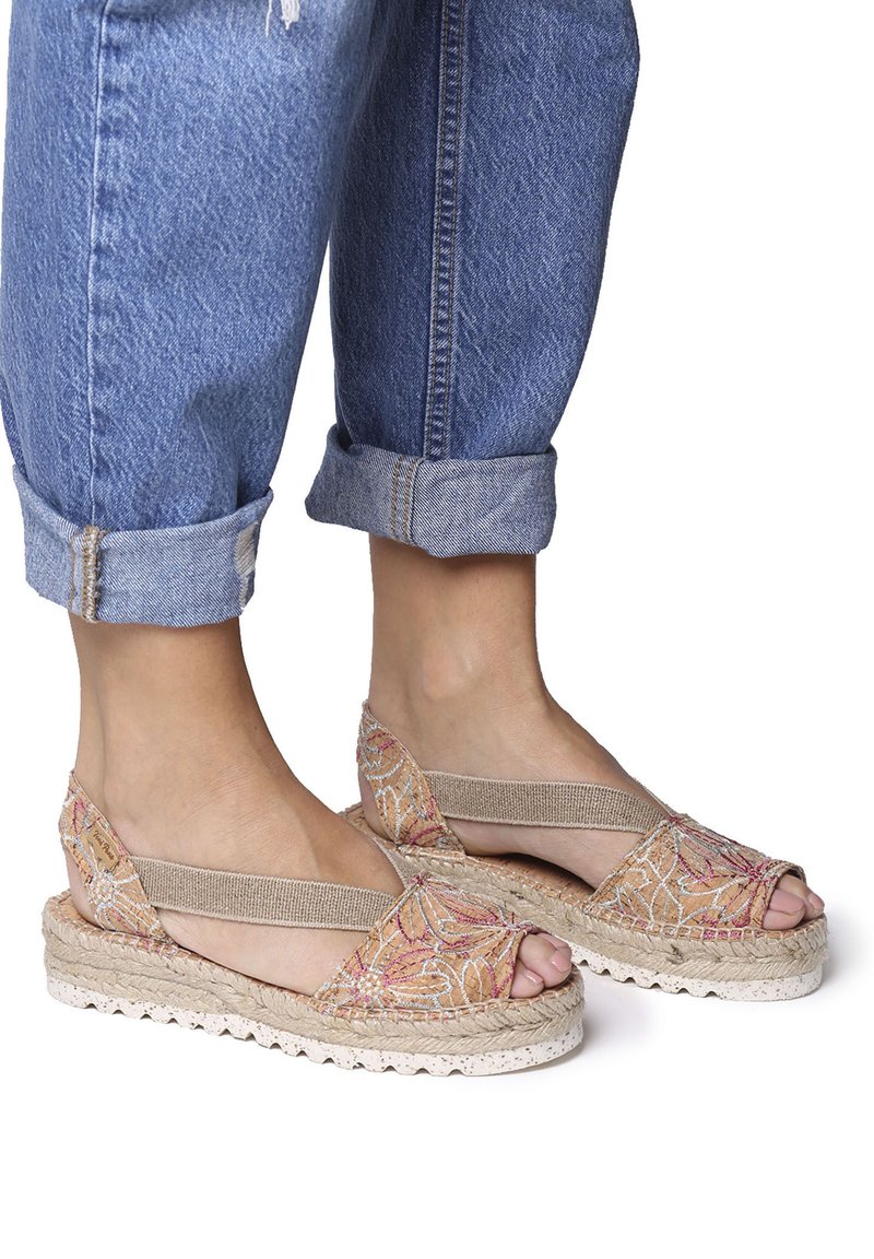 Sandali espadrilles beige con motivi floreali ricamati, punta aperta e cinghie elastiche, caratterizzati da una suola in juta testurizzata e dettagli bianchi.