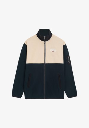 Fleecová bunda v tmavě modré a béžové barvě s vysokým límcem, plným zipem, dvěma bočními kapsami a kapsou na levém rukávu. Dekorativní tekst na hrudi.