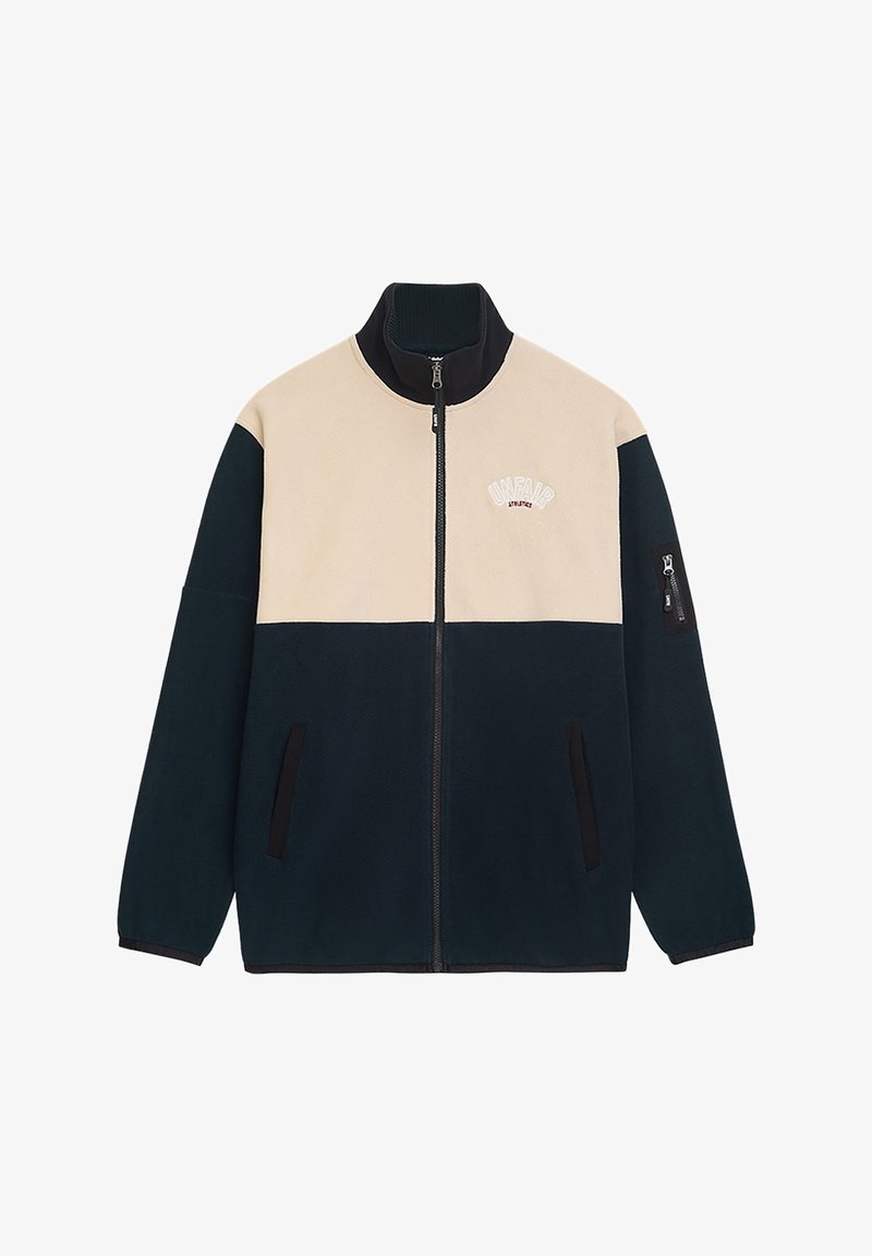 Tamsiai žalia ir smėlio spalvos vilnos striukė su aukštu kaklu, pilnu užtrauktuku, dviem šoninėmis kišenėmis ir kairiuoju rankovės kišeniu. Dekoratyvinis tekstas krūtinėje.