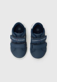 Marineblå barne sneakers med to borrelåser, hvite detaljer og "TOMMY HILFIGER" branding. Laget av syntetisk materiale, rund tåform.